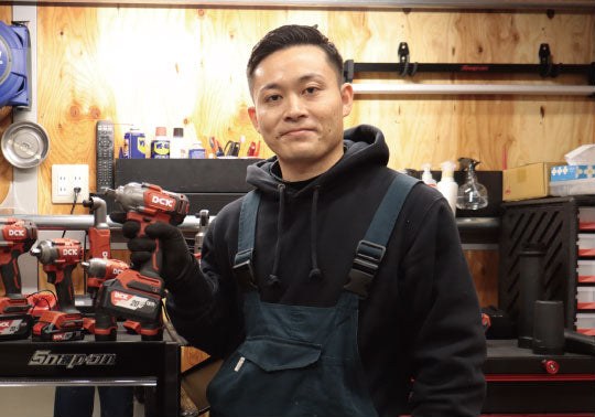 髙橋雄也さん（自動車整備士・インフルエンサー）。整備工場でDCKのインパクトレンチを手にした様子